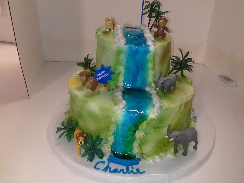 Jungle-themed birthday cake with waterfall, animals, and 