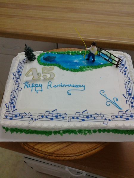 Cake decorated with a pond and a fisherman, plus music notes and 