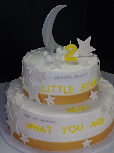 Two-tiered white cake with gold trim, star and moon decorations, 