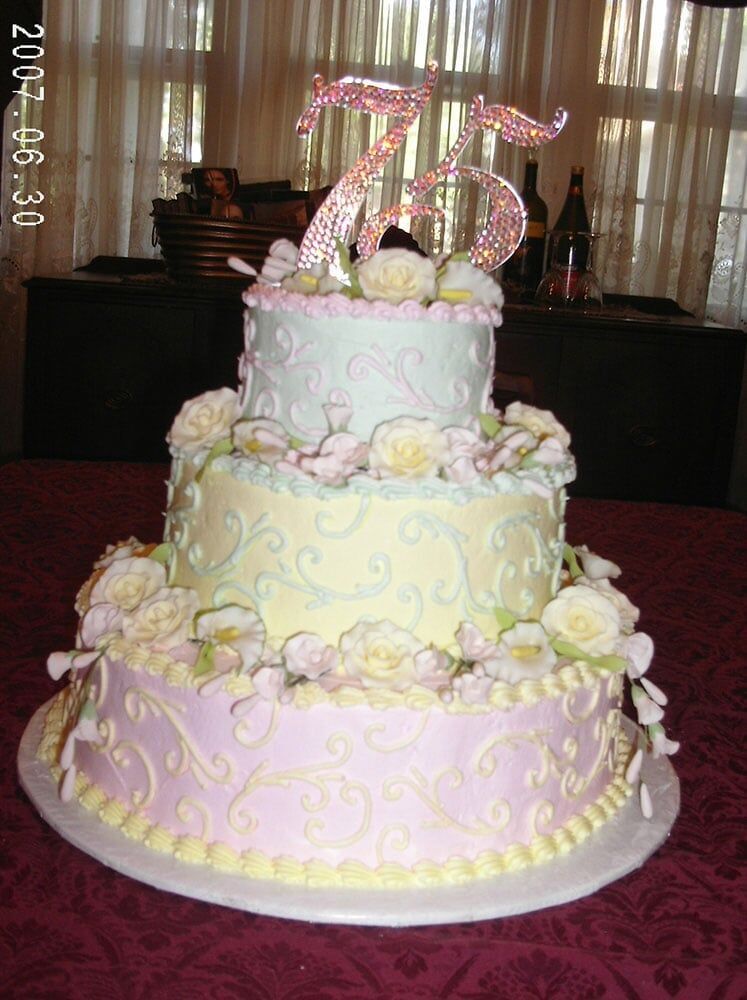 Three-tiered pastel cake with floral decorations and 