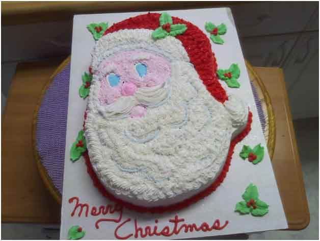 Santa Claus cake with red hat and beard, decorated with frosting. 