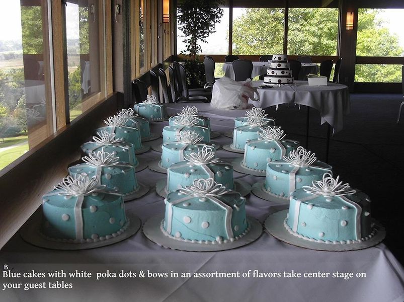 Light blue cakes with white polka dots and bows on a table.