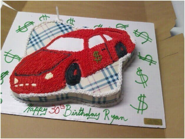 Red car-shaped birthday cake on plaid pattern; 