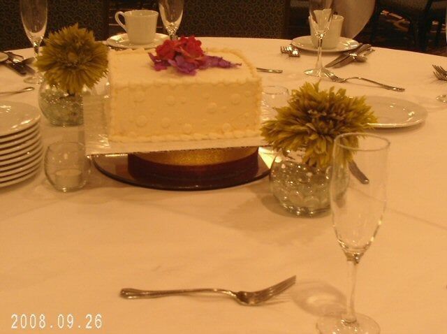 Wedding cake on a table set for guests, with flowers and champagne glasses.