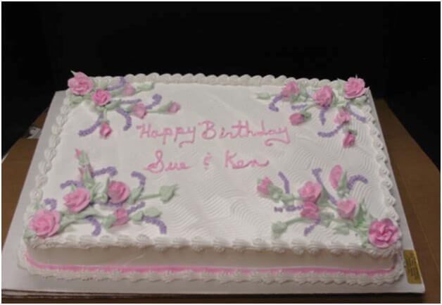 Birthday cake with pink frosting, flowers, and 