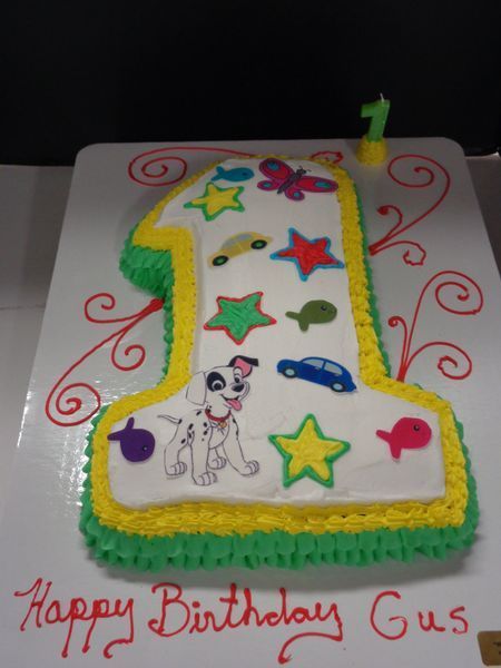 Cake shaped like a number one, decorated with cartoon images and 