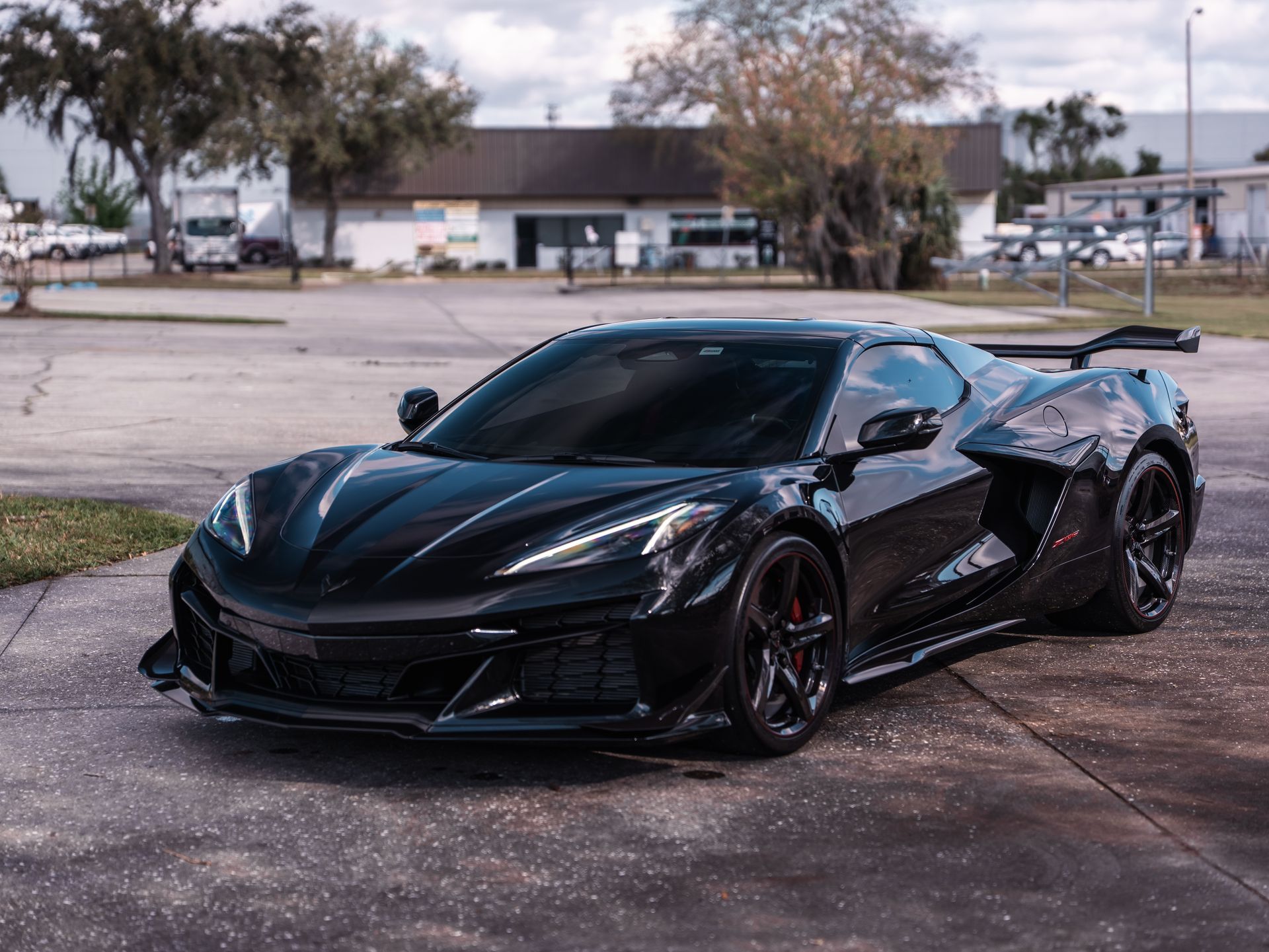 A black sports car is parked in a parking lot.
