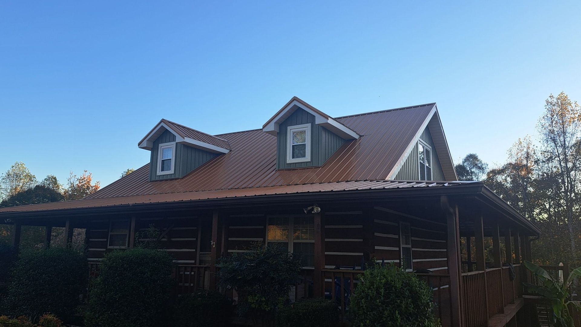 A log cabin with a red roof and a blue sky in the background