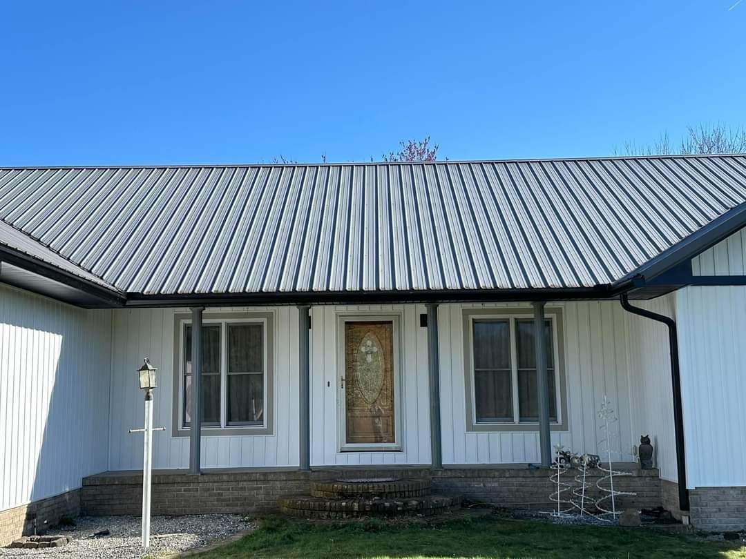 A white house with a metal roof and a porch