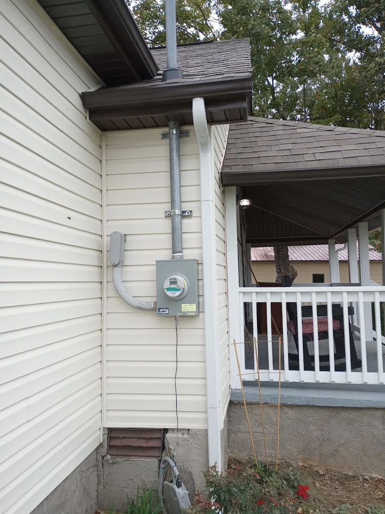 A white house with a electrical box on the side of it