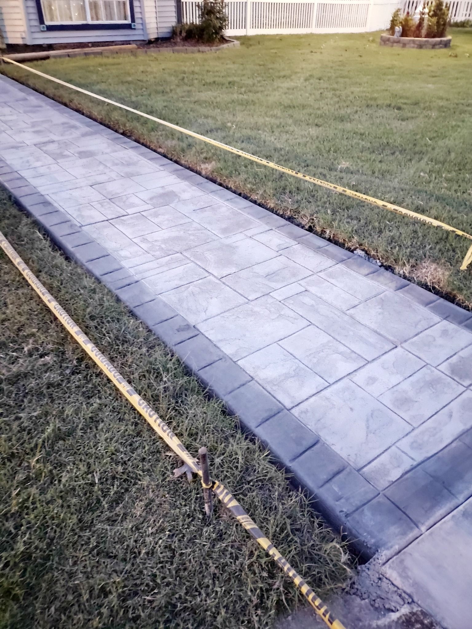 A sidewalk is being built in front of a house.