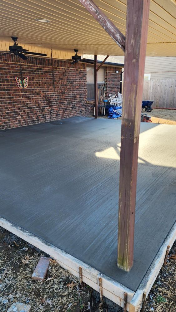 A concrete driveway is being built in front of a brick building.