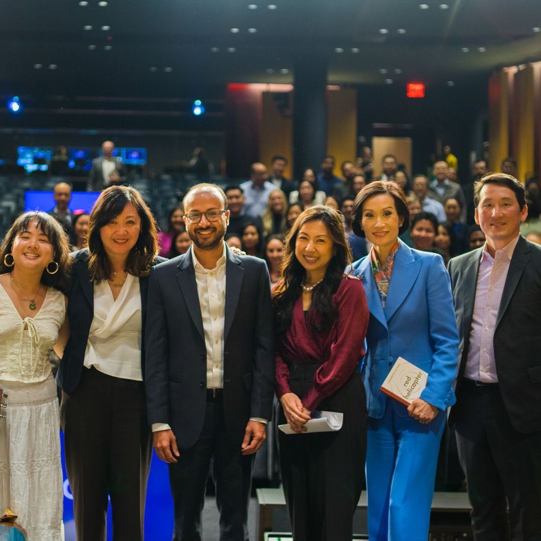 A group of people posing for a picture in front of a crowd