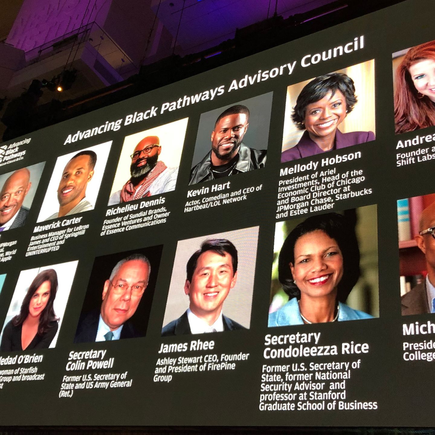A large screen displays a list of advisory council members