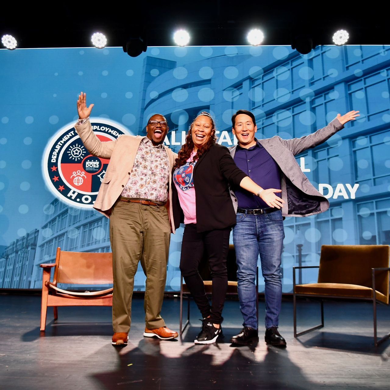 Three people are posing for a picture on a stage in front of a sign that says k.o.