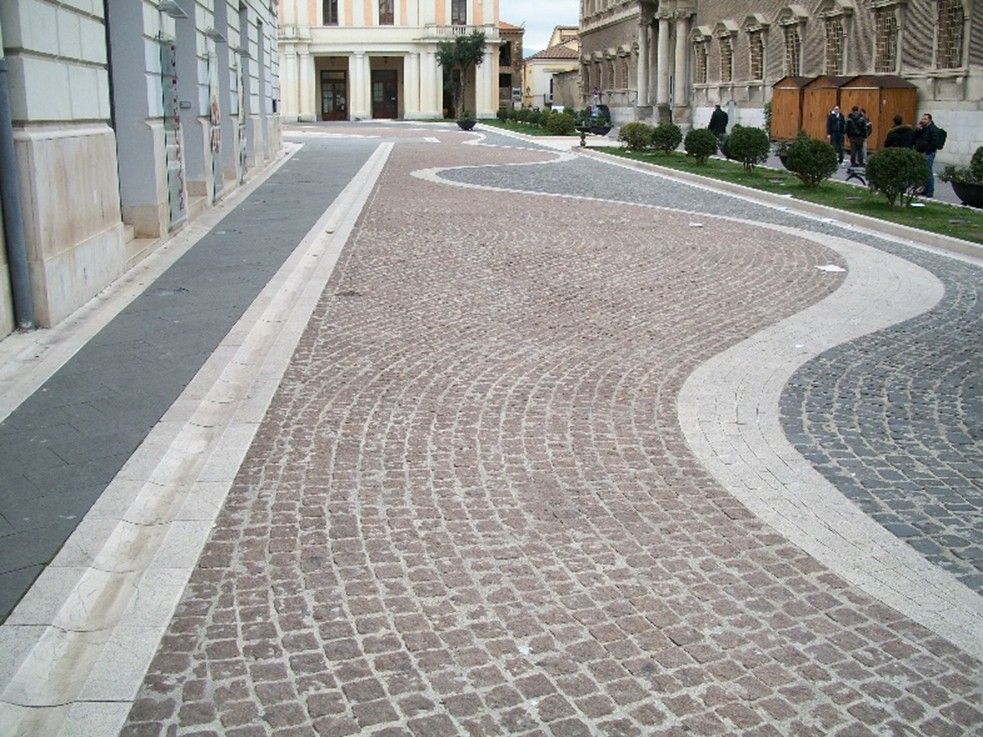 Una strada acciottolata con un edificio sullo sfondo