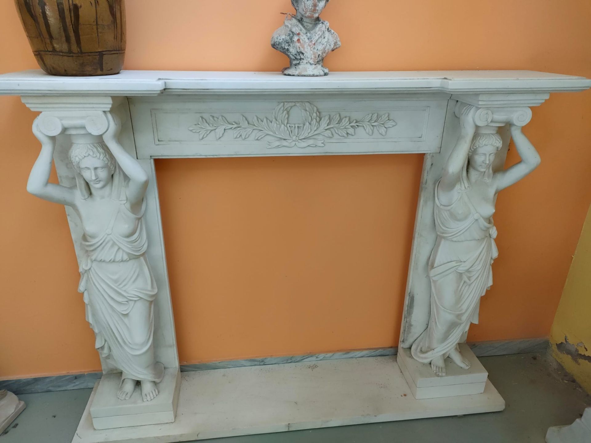 Un camino con due statue di donne sopra