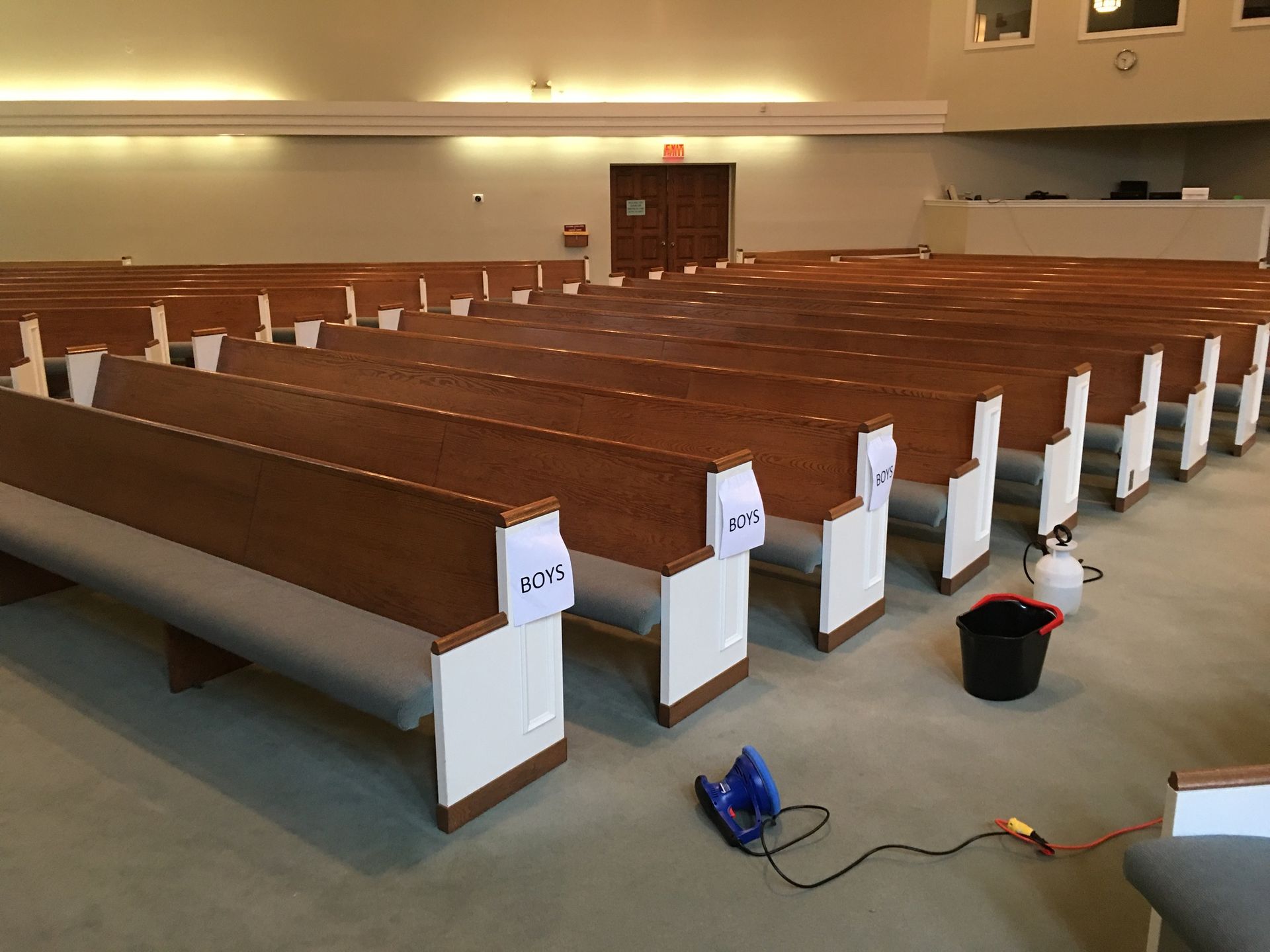 A church with rows of wooden benches and white trim