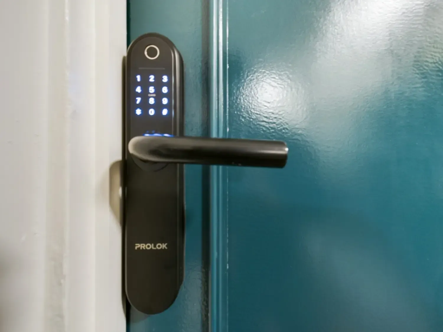 Keypad smart door lock with handle on a teal door