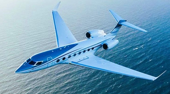 Airplane landing, coming toward the viewer, against a clear blue sky.