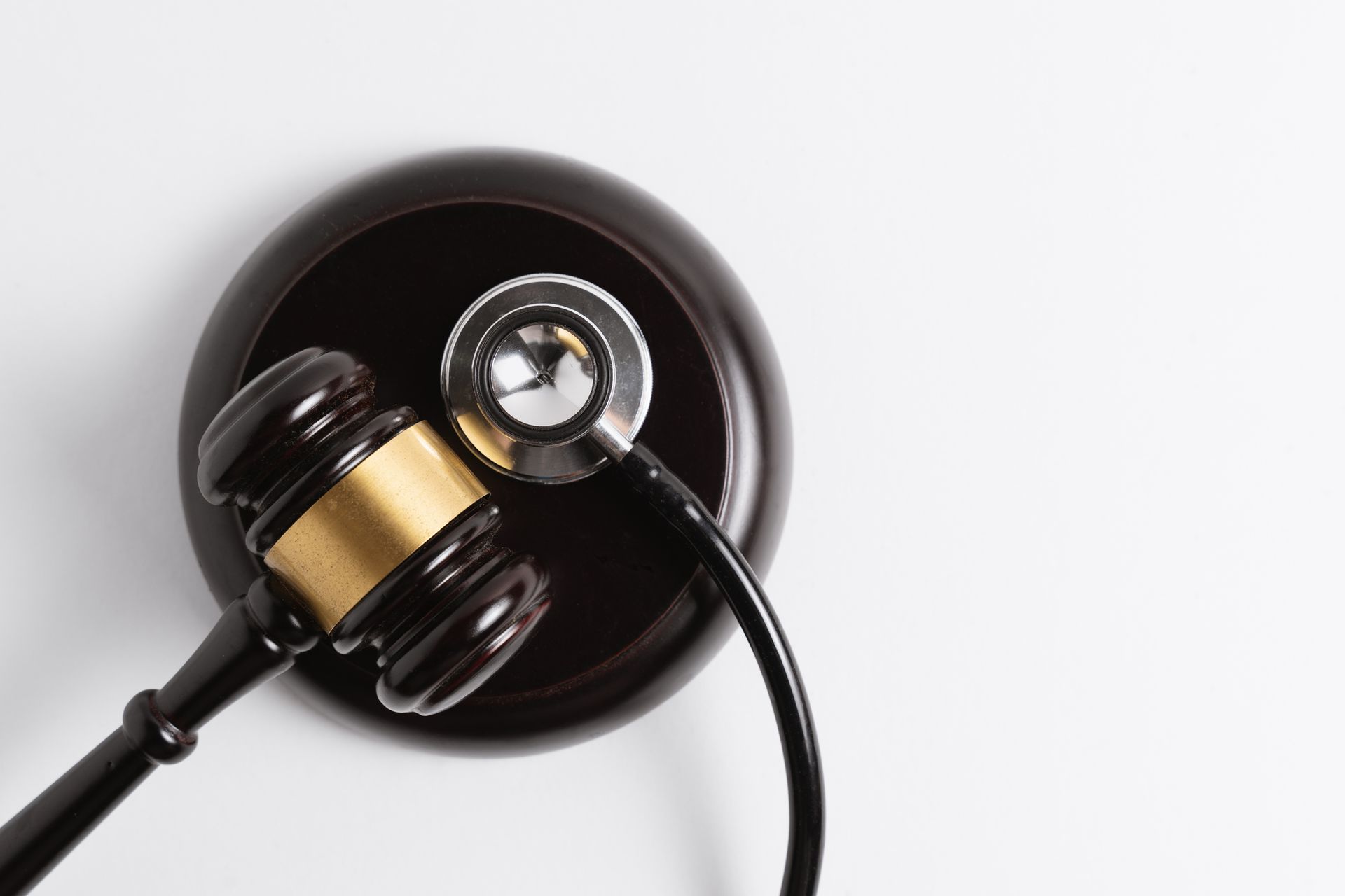A judge 's gavel with a stethoscope attached to it.
