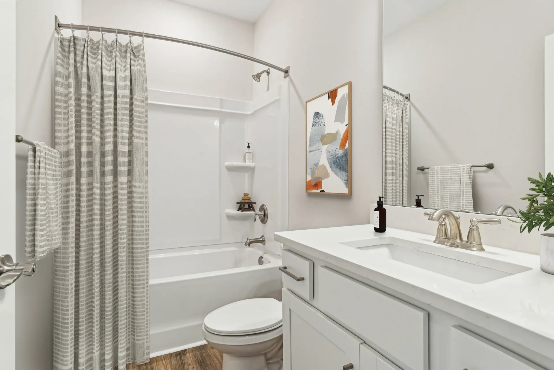 Bathroom in an apartment featuring a white vanity, sink, toilet, and a shower/tub.