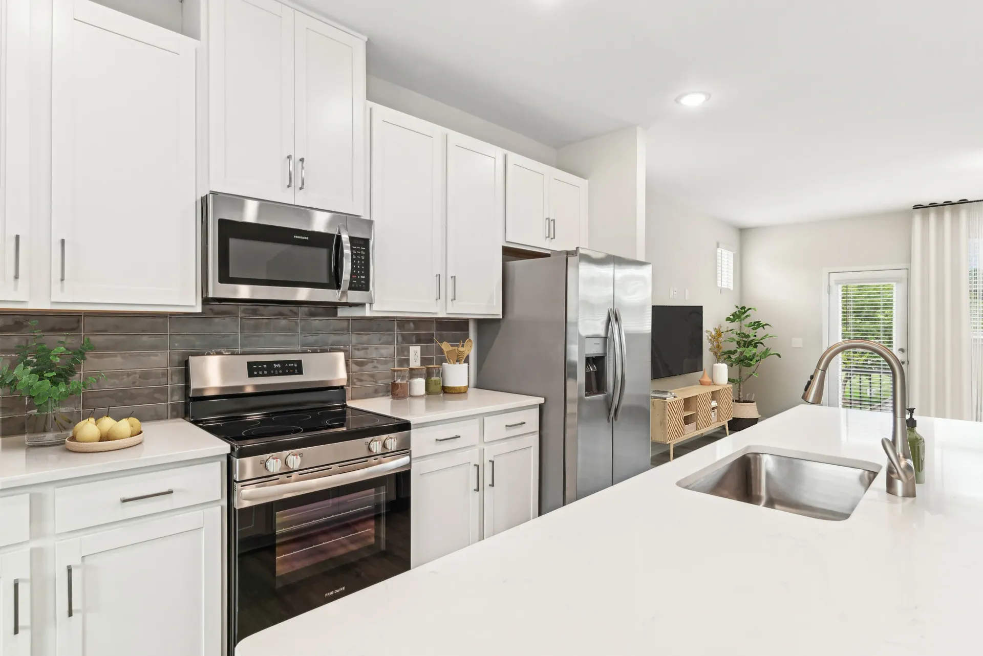 Modern white kitchen with stainless steel appliances and a large island.