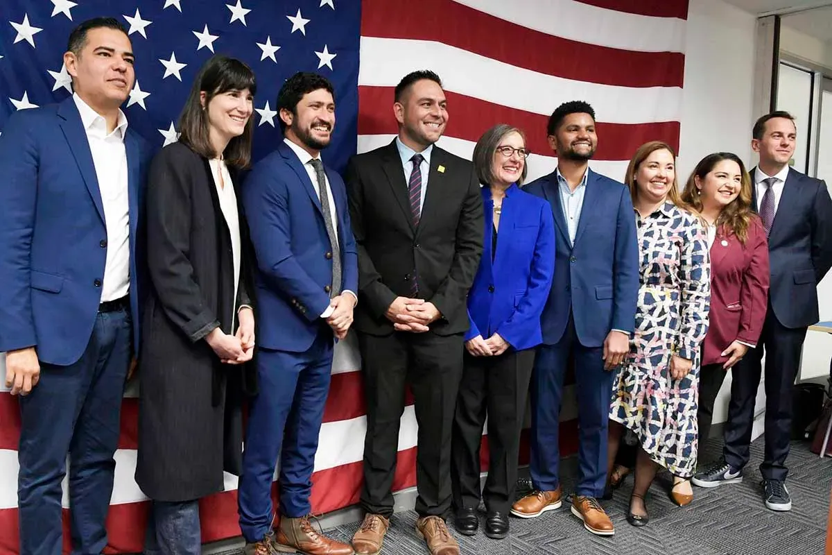 A group of people standing in front of an american flag.