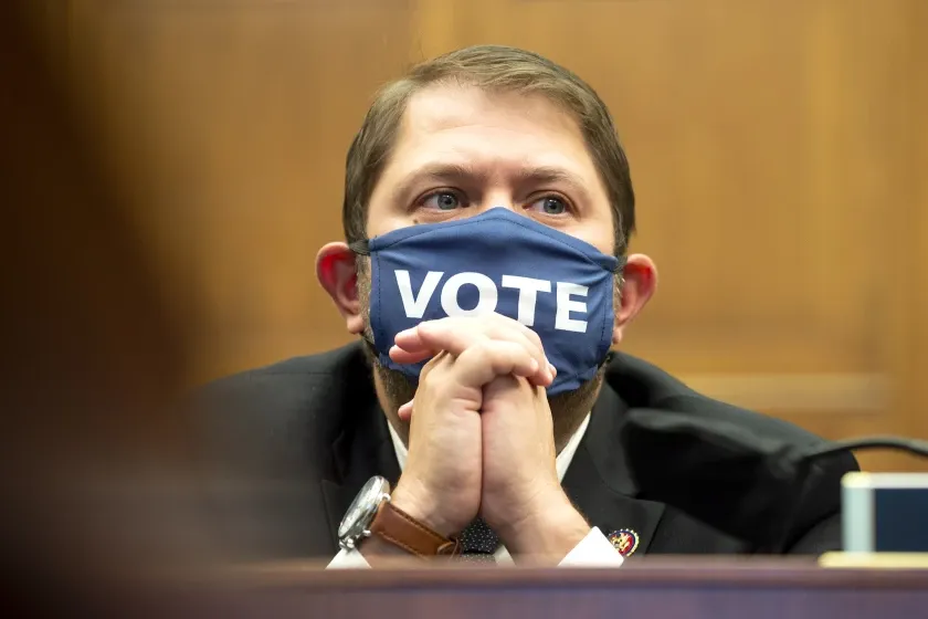 A man wearing a face mask with the word vote on it.