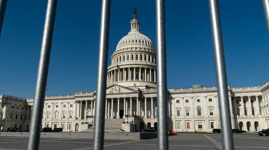 A view of the capitol building through a fence