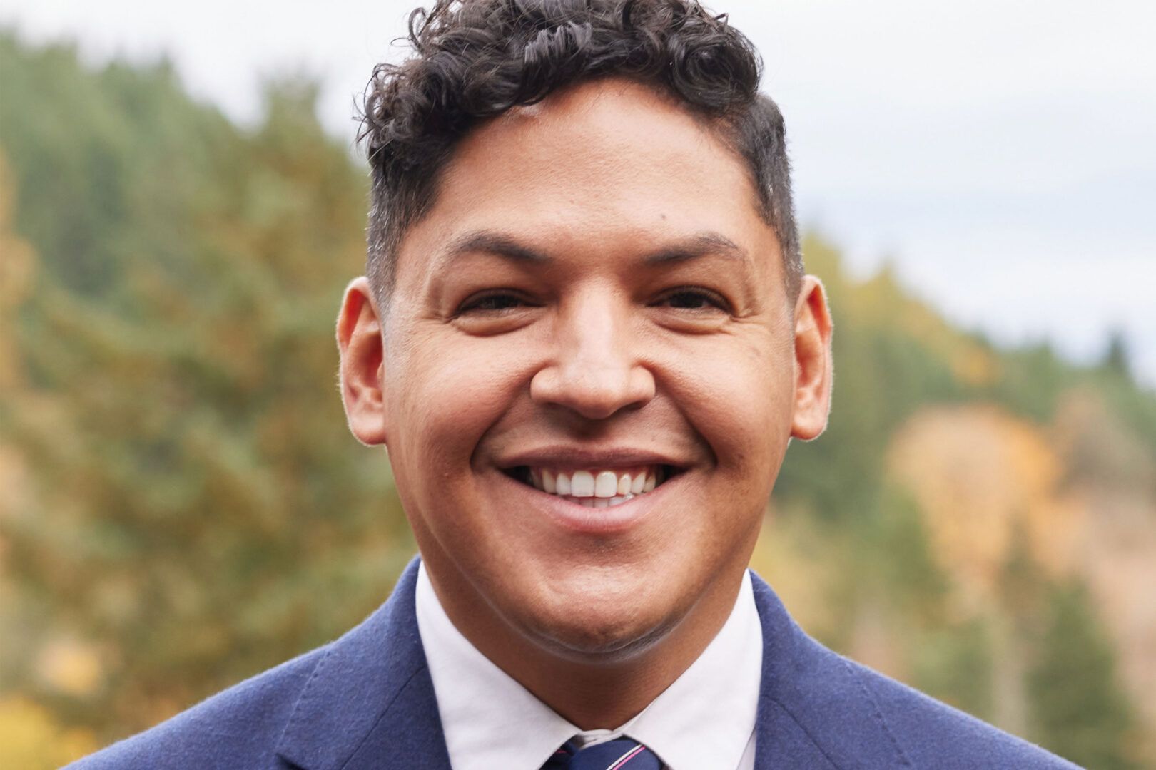 A man in a suit and tie is smiling for the camera.