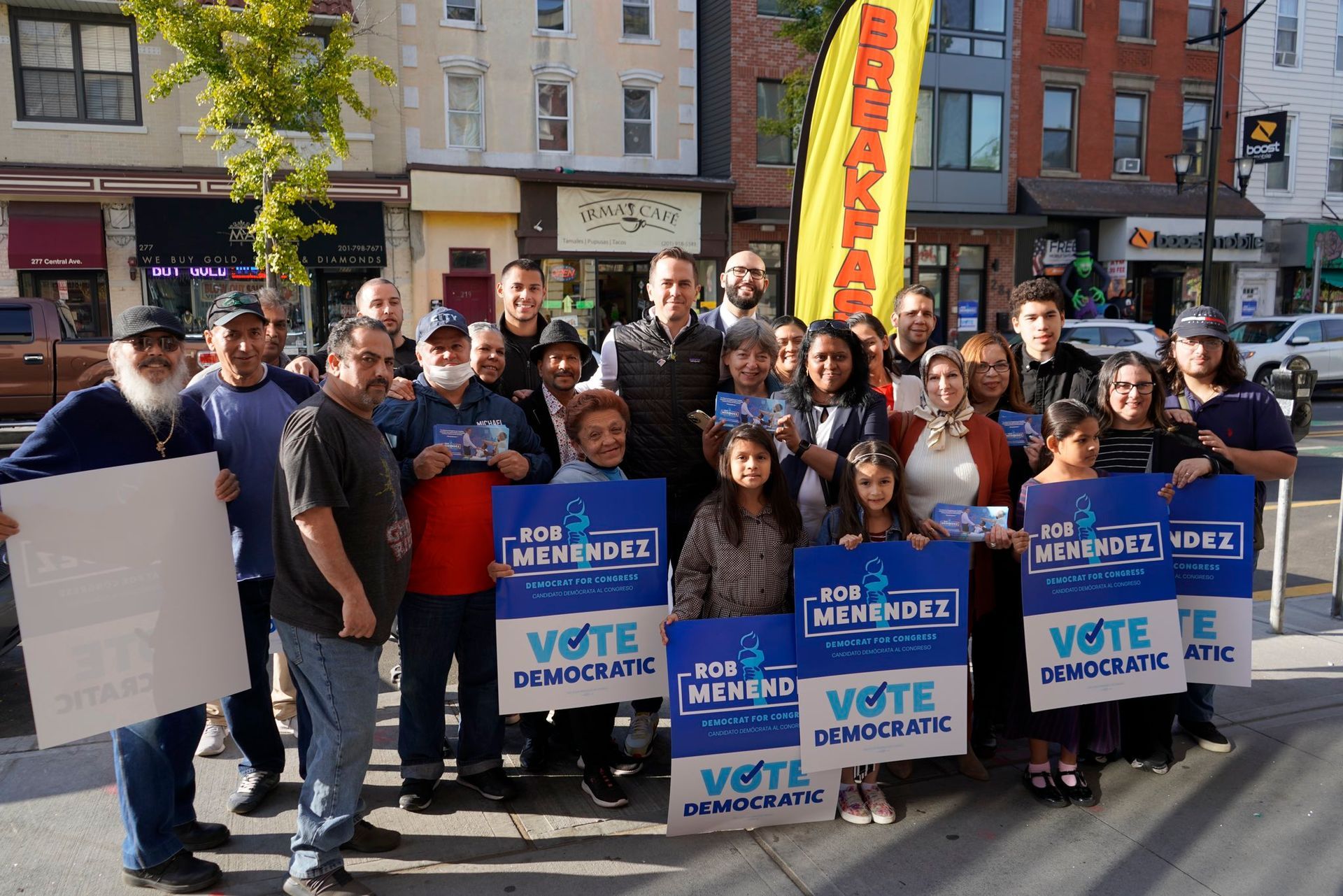 A group of people standing on a sidewalk holding signs that say vote