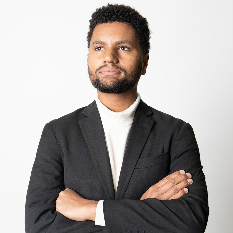 A man in a suit with his arms crossed