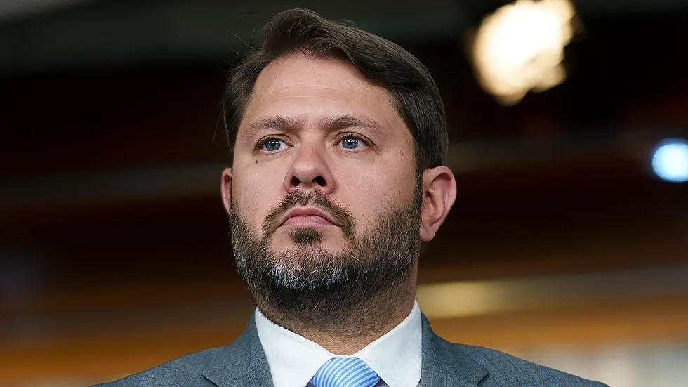 A man with a beard is wearing a suit and tie.