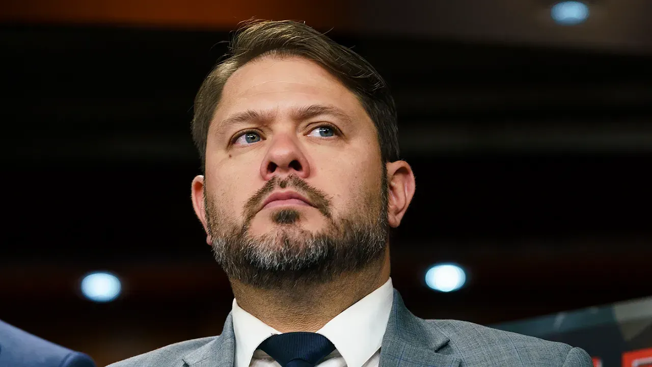 A man with a beard is wearing a suit and tie.