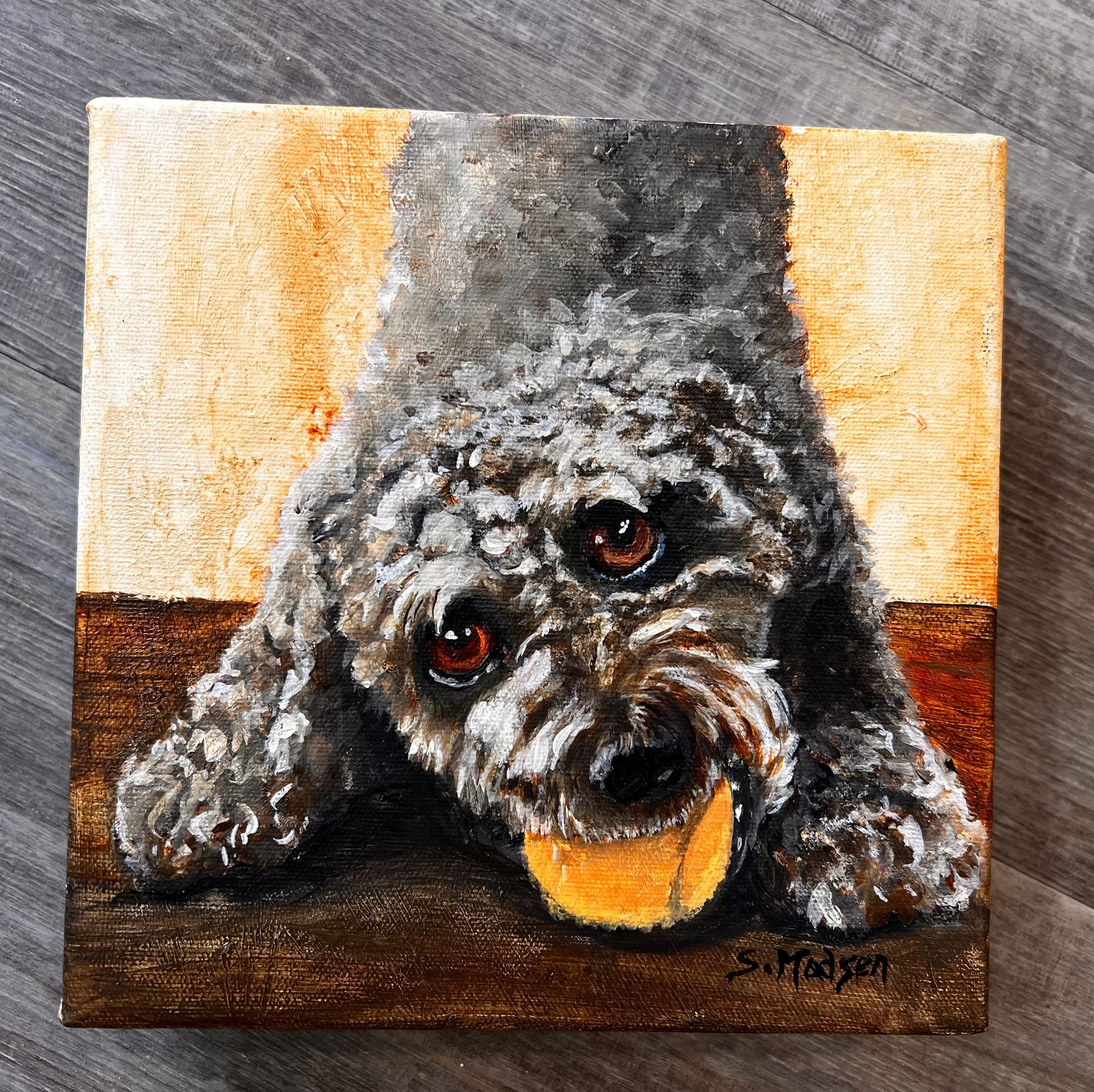 A painting of a dog laying down with a piece of food in its mouth.
