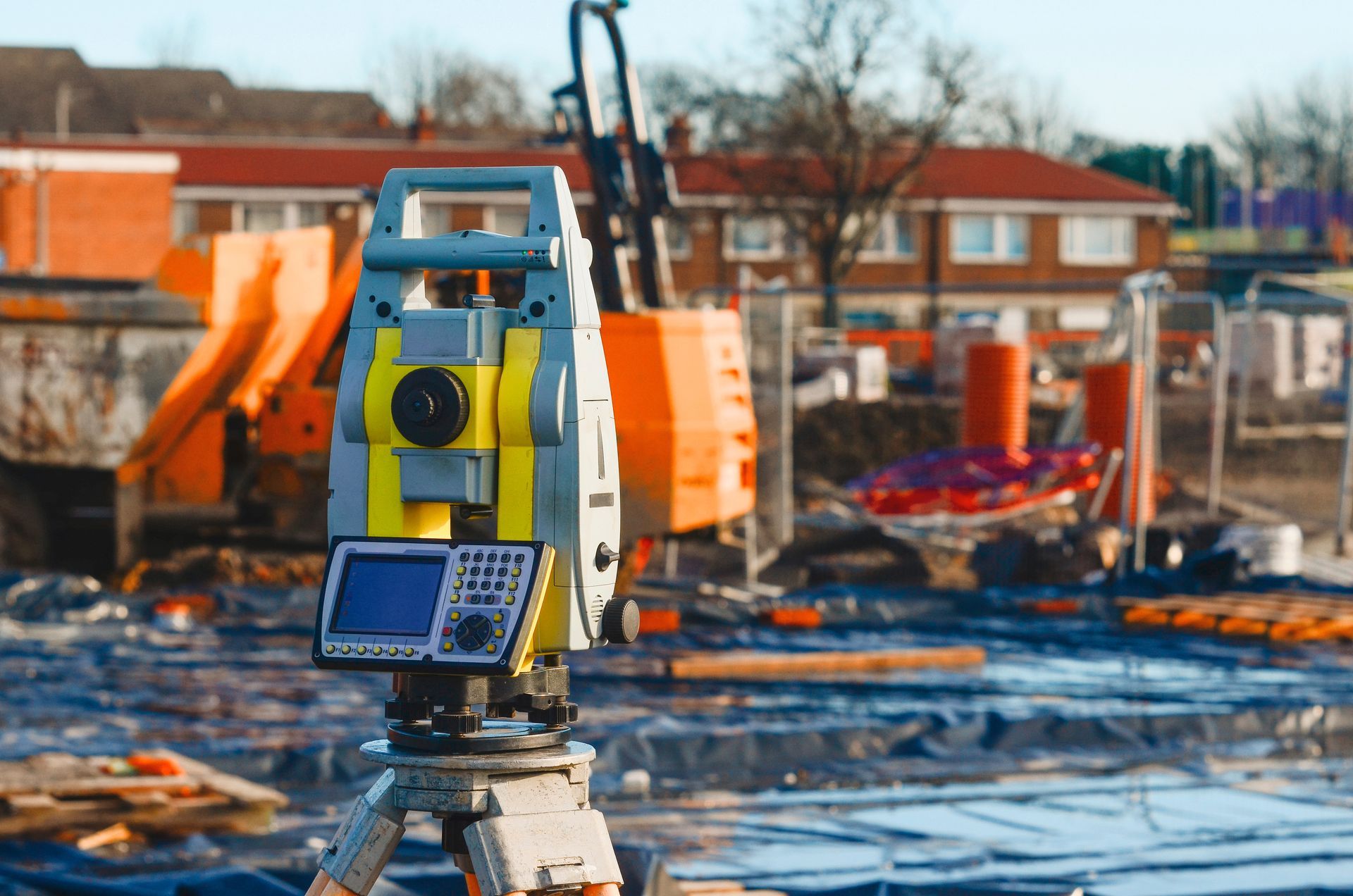 Land surveyors equipment theodolite or total positioning station set on tripod on construction site.