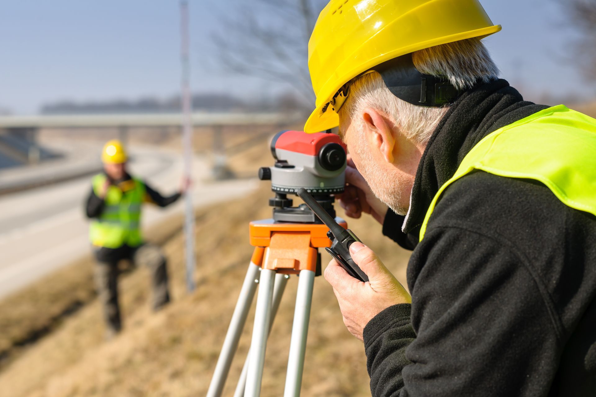 A man is using an optical level to ensure accuracy in their measurements. A man is using an optical level to ensure accuracy in their measurements.
