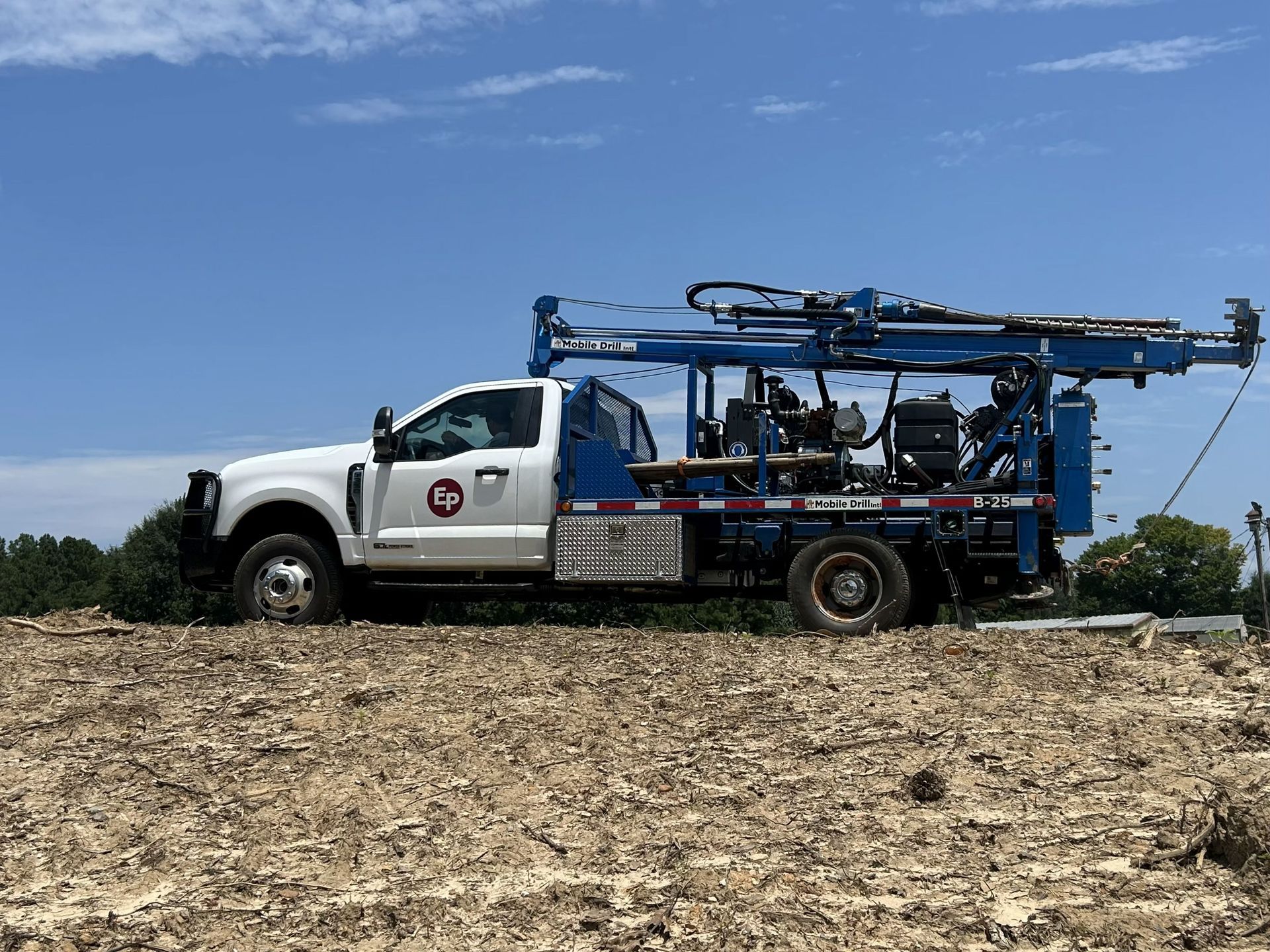 Geotechnical Research And Design — Meridian, MS — Engineering Plus, Inc. Red drilling rig truck in a field on a foggy morning. Trees in the background.