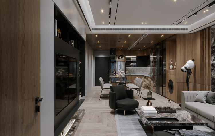 A modern living room with wood paneling, a dark accent wall, grey furniture, and an open-plan kitchen area.