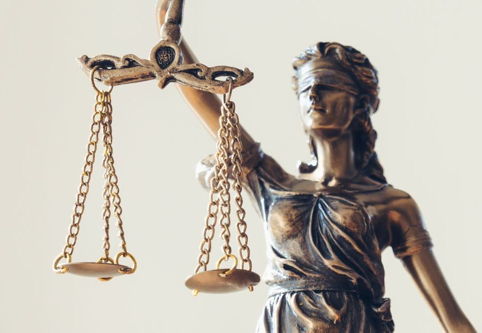 Statue der Justitia mit Waage in der Hand, mit verbundenen Augen, bronzefarben.