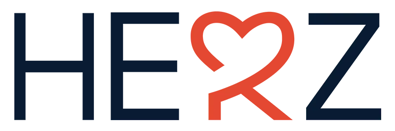 „HERZ“-Schriftzug mit einem roten Herzsymbol anstelle des „E“. Die übrigen Buchstaben sind dunkelblau.