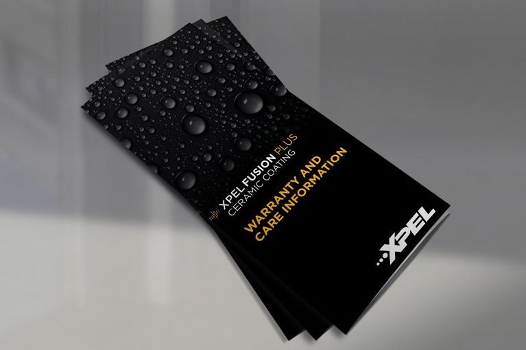 Black brochure with water droplets, featuring orange and white text on a gray surface.