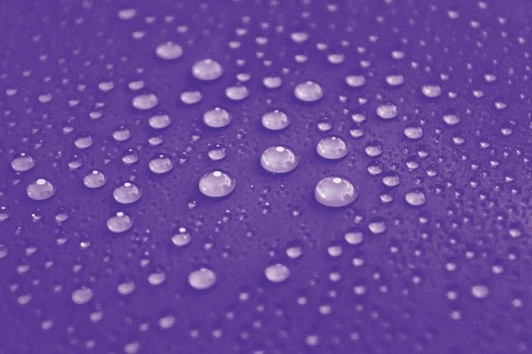 Purple surface covered with water droplets