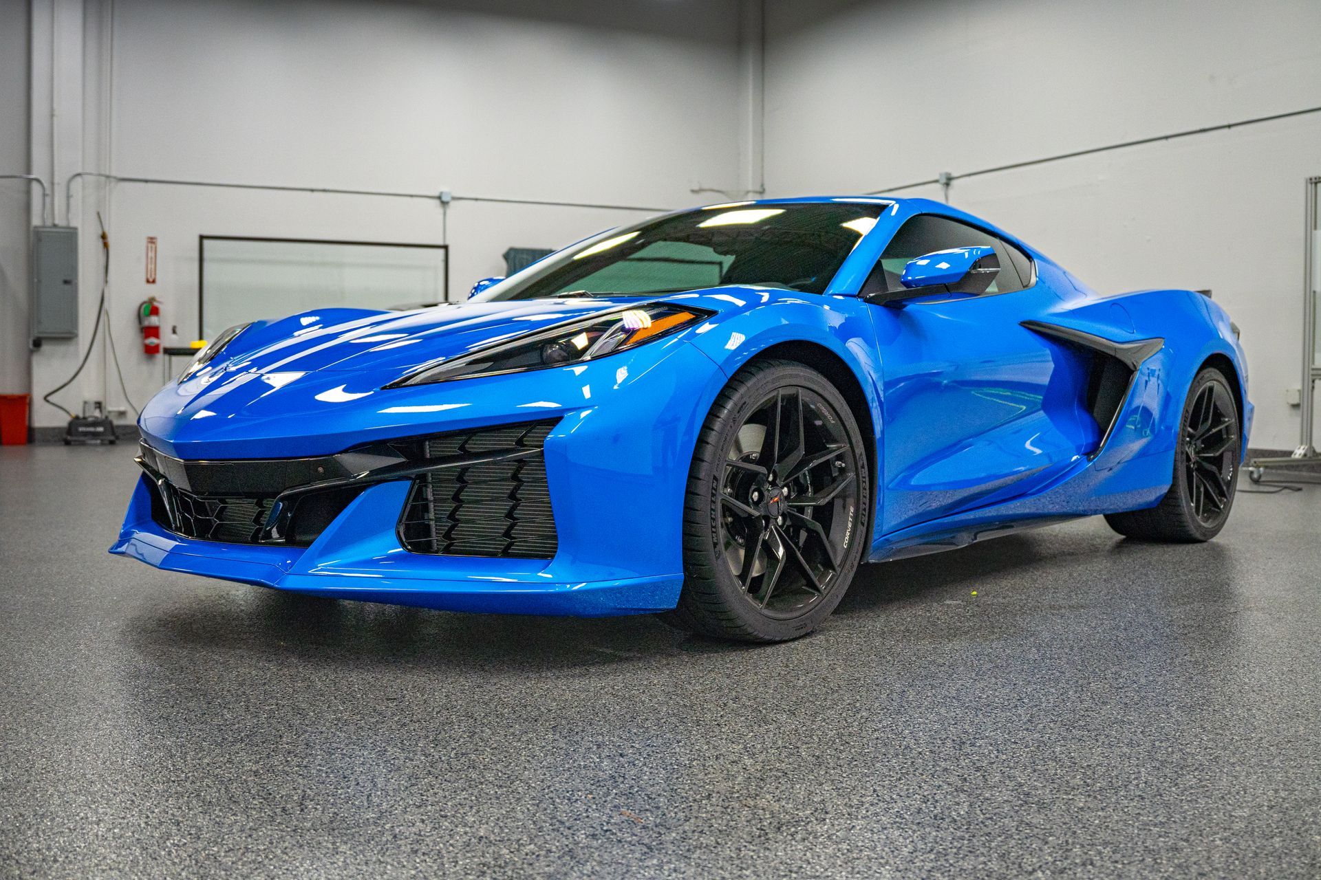 Blue sports car in a garage with a gray polished floor