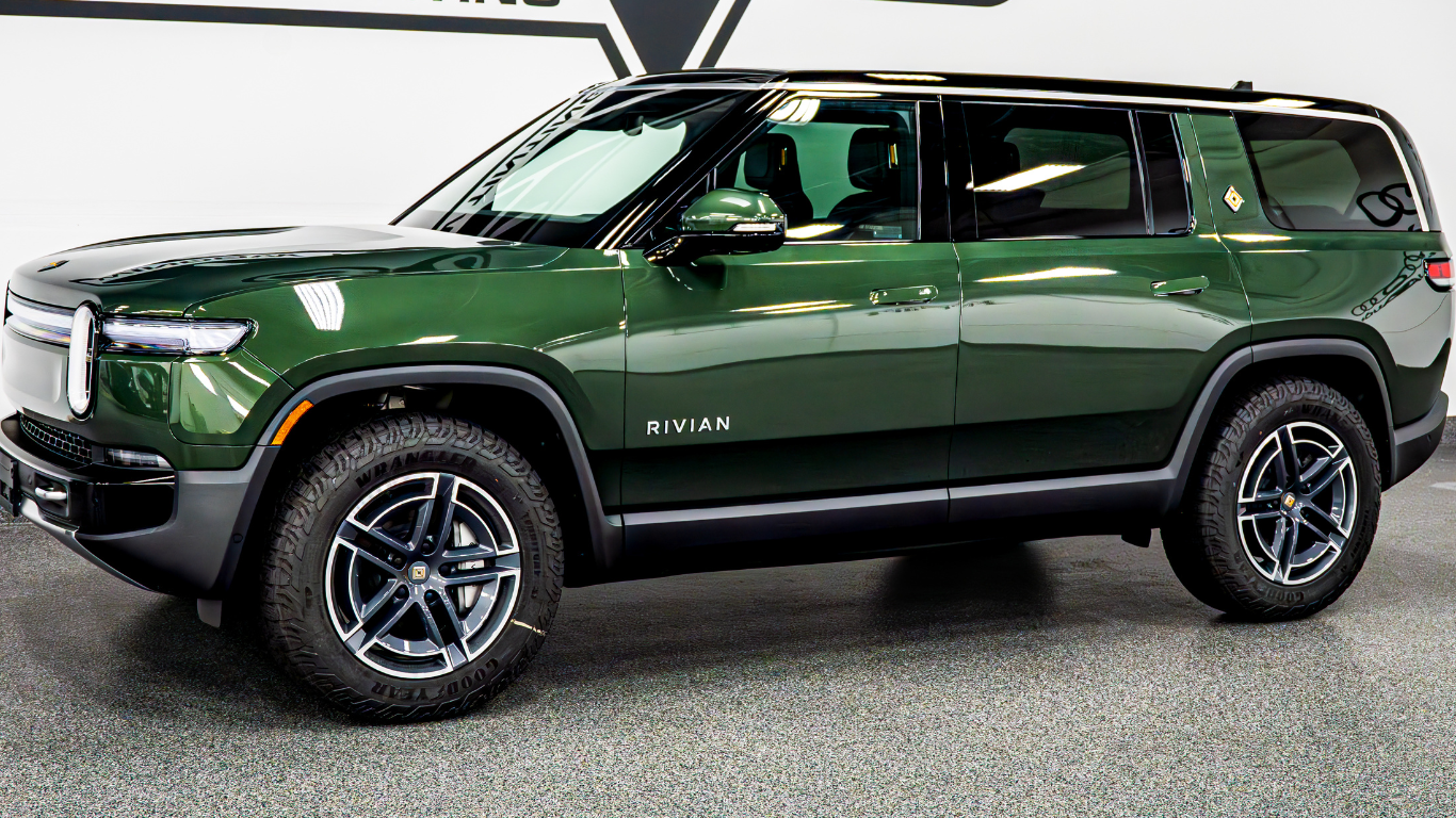Dark green SUV parked indoors, side view against a light background.