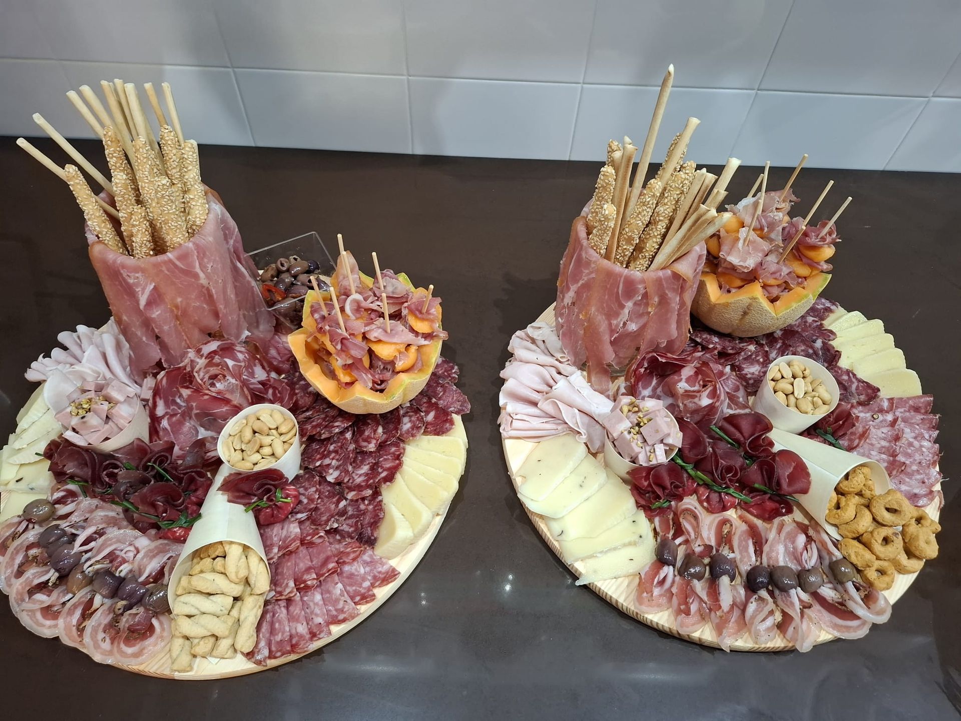 Due taglieri di salumi, formaggi, cracker e grissini su un tavolo