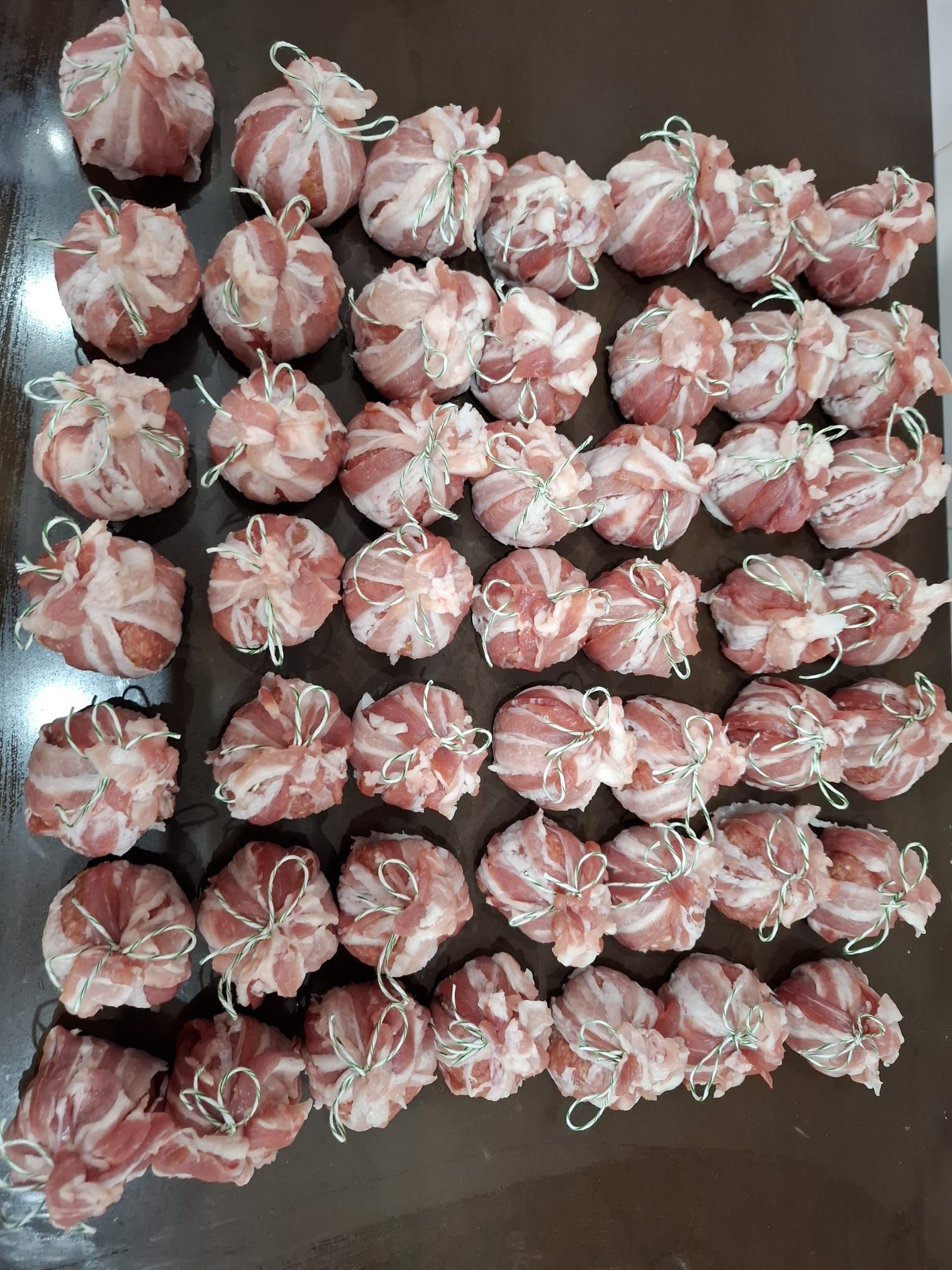 Caramelle assortite rosa e bianche incartate, disposte in file su una superficie scura