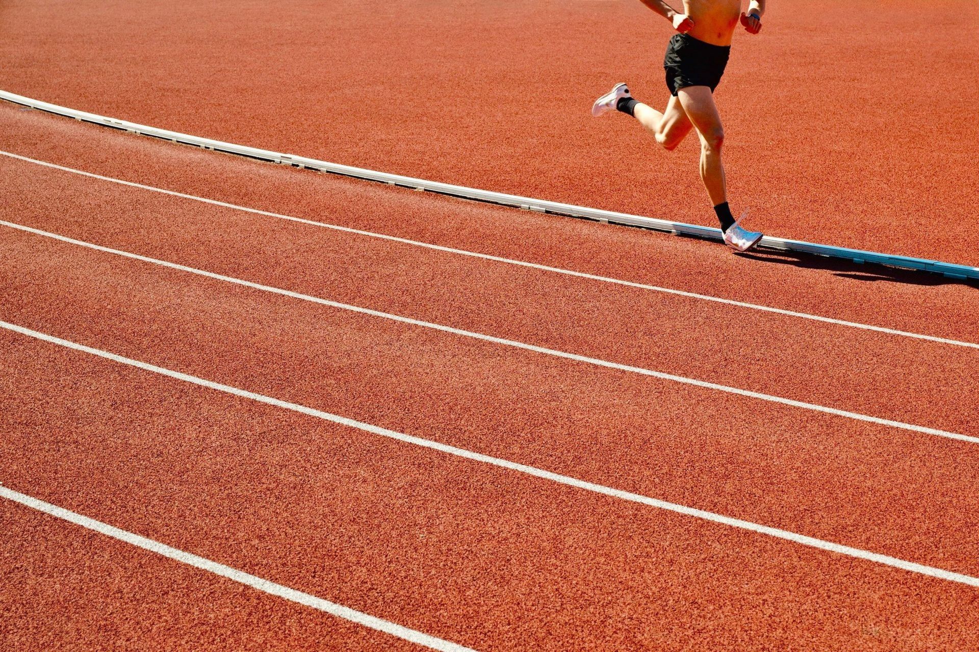Runner sprinting on a track, representing a former athlete getting back in shape