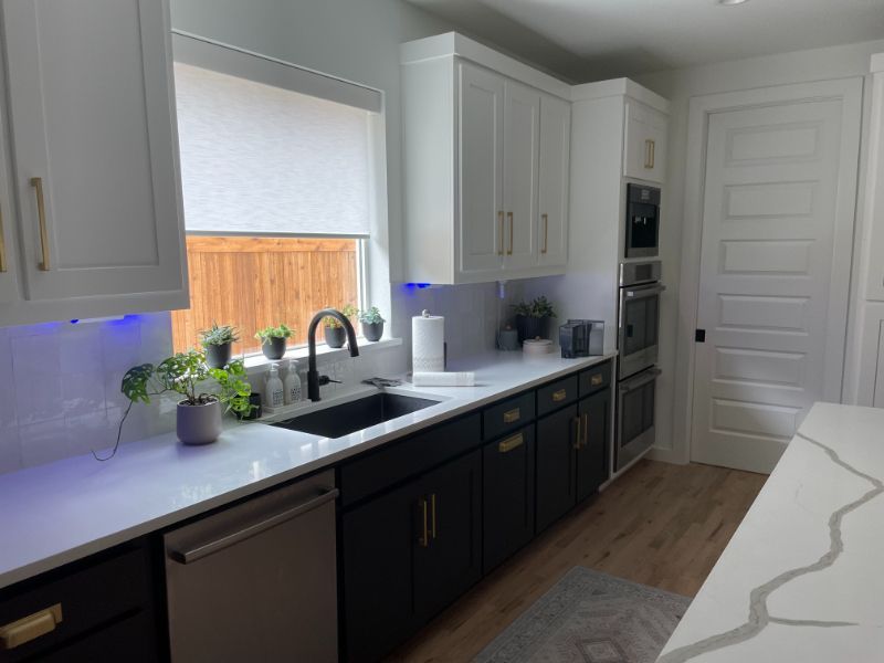 A kitchen with white cabinets , black cabinets , a sink , and a window. Love is Blinds Arizona (844) 936-2446